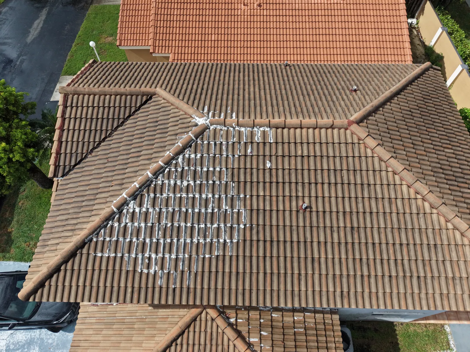 Drone photo showing patched tiles on a barrel tile roof