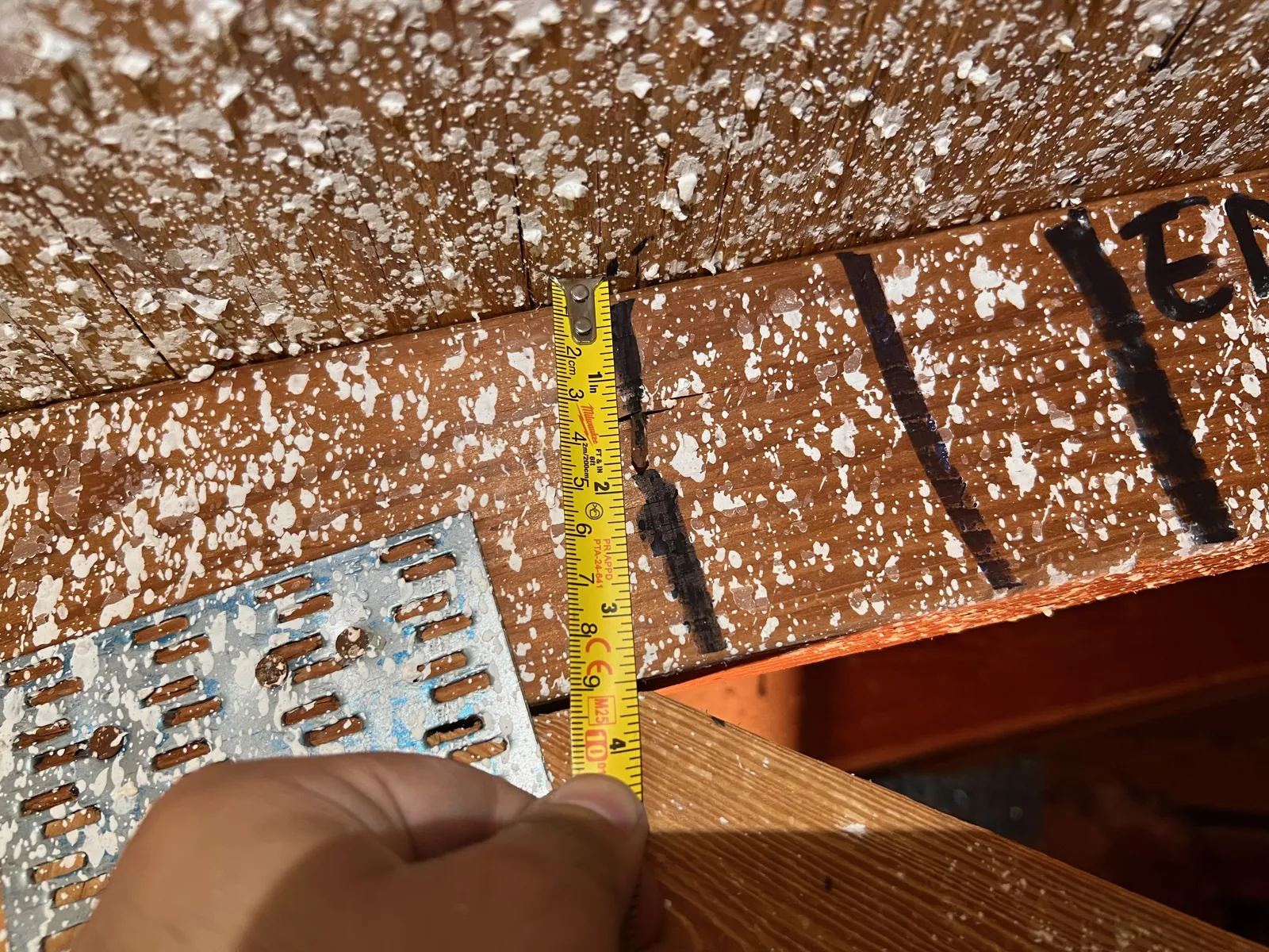 Measuring roof deck nail spacing in an attic